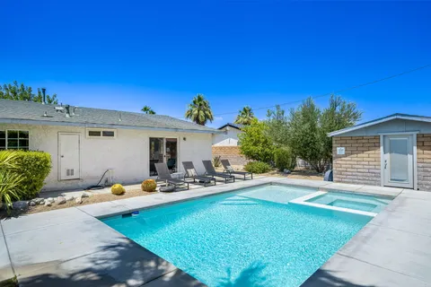 a view of a house with backyard and sitting area