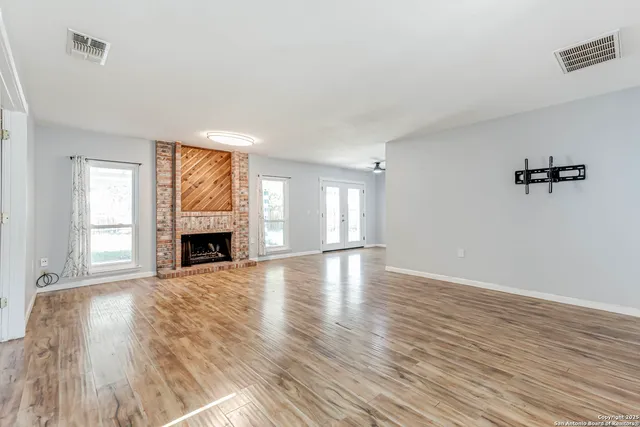 a view of empty room with wooden floor and fireplace