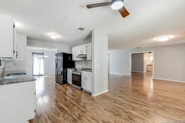 a large kitchen with stainless steel appliances granite countertop a stove and a refrigerator