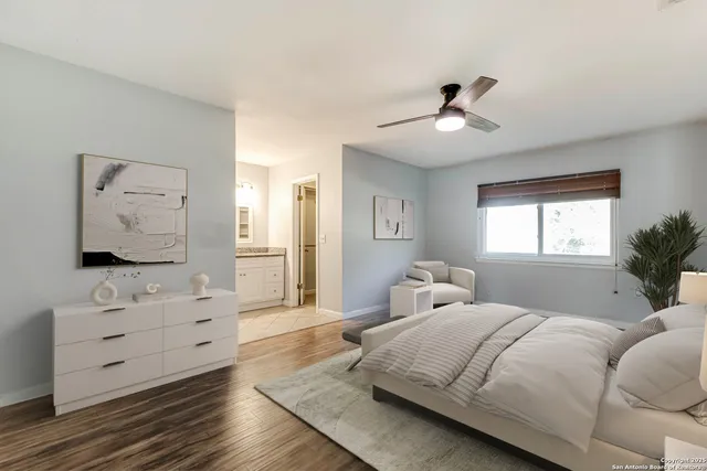 a bedroom with a large bed and a flat tv screen on dresser