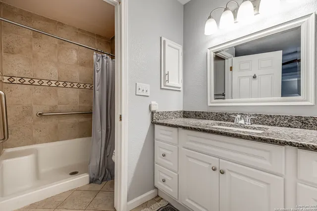 a bathroom with a granite countertop sink mirror and vanity