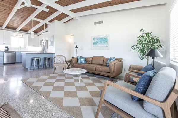 a living room with furniture and a dining table with wooden floor