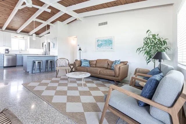 a living room with furniture and a dining table with wooden floor