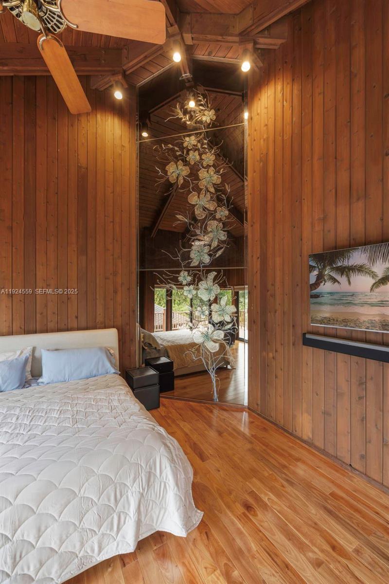 21675 Southwest 232nd Street Miami, FL 33170 - Photo 40 of 82 a bedroom with a bed and a chandelier