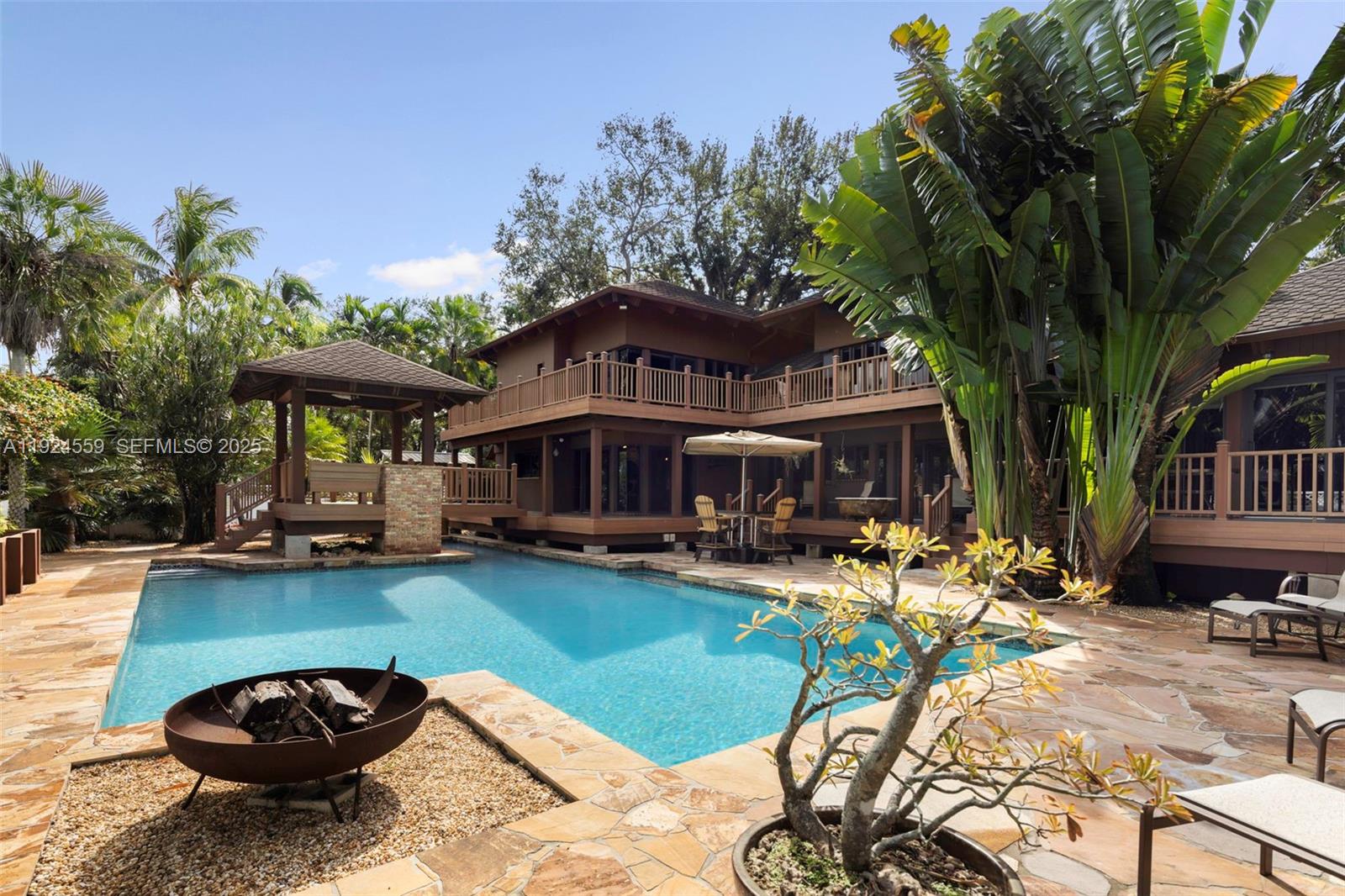 21675 Southwest 232nd Street Miami, FL 33170 - Photo 63 of 82 a view of a swimming pool with lawn chairs under an umbrella