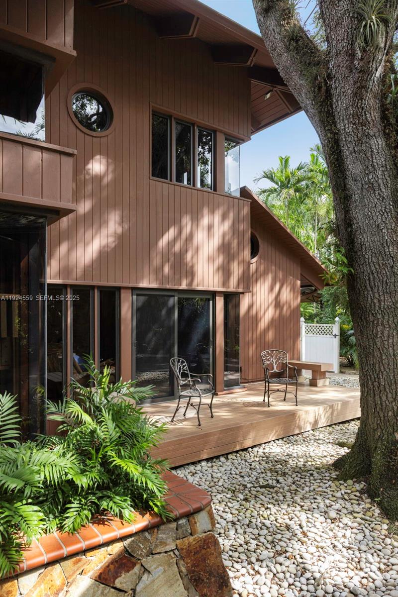 21675 Southwest 232nd Street Miami, FL 33170 - Photo 70 of 82 a view of a patio with table and chairs with wooden floor and plants