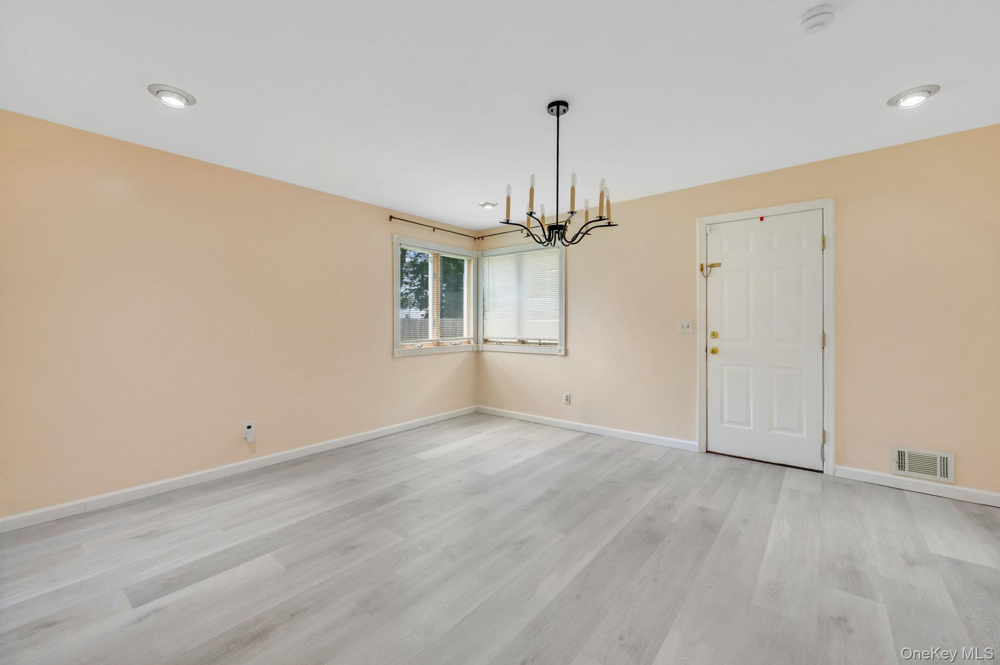 10 Laurie Road Brentwood, NY 11717 - Photo 11 of 29 Unfurnished dining area featuring a chandelier and light wood-style flooring