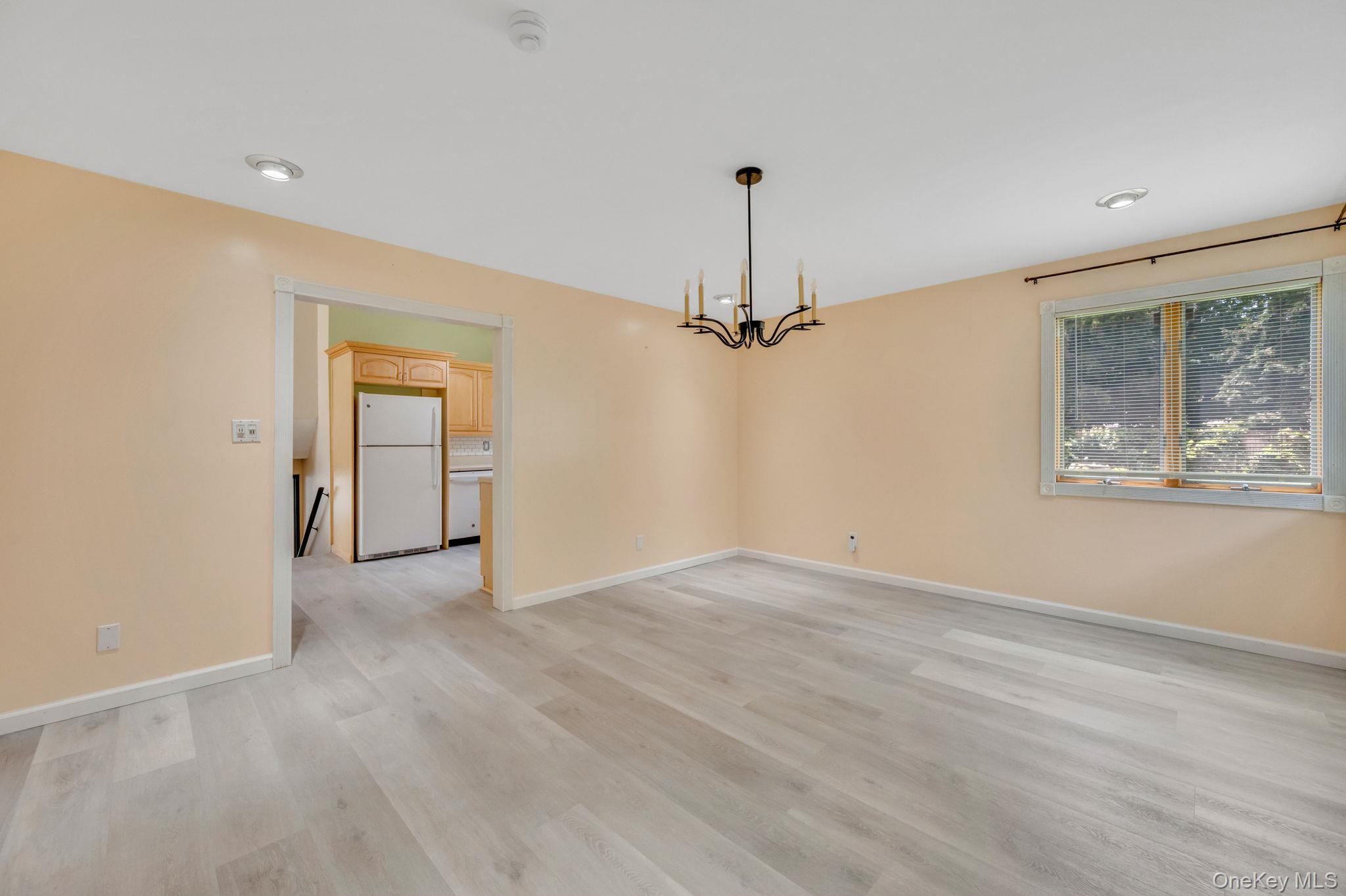 10 Laurie Road Brentwood, NY 11717 - Photo 12 of 29 Spare room with light wood-style floors and a chandelier