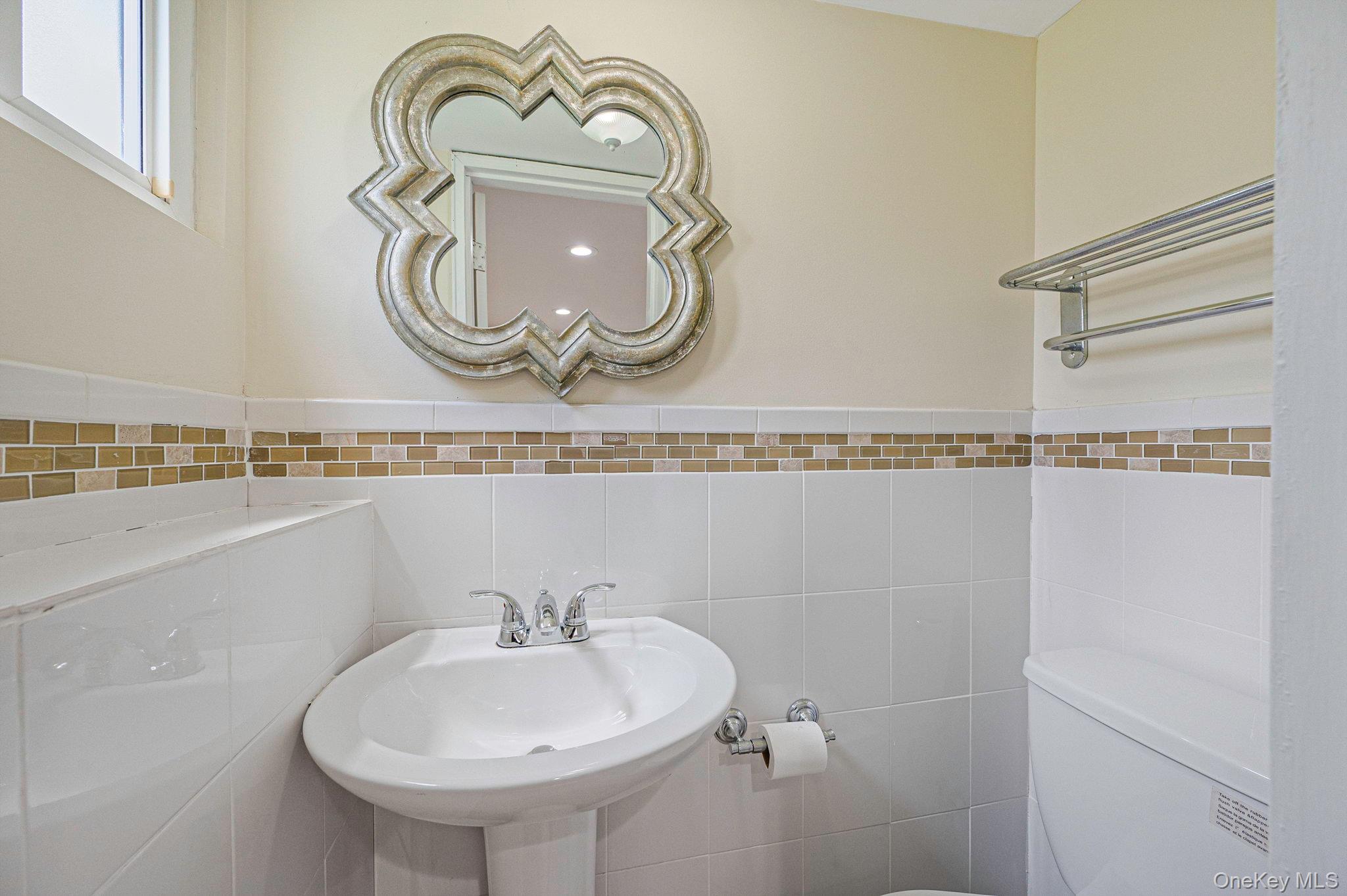 10 Laurie Road Brentwood, NY 11717 - Photo 22 of 29 Half bathroom with toilet and tile walls