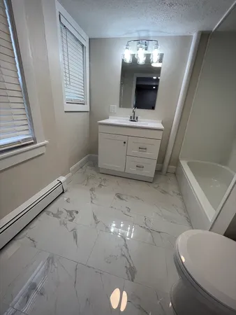 a bathroom with a sink a toilet and mirror