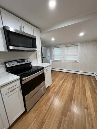 a kitchen with wooden floors and stainless steel appliances