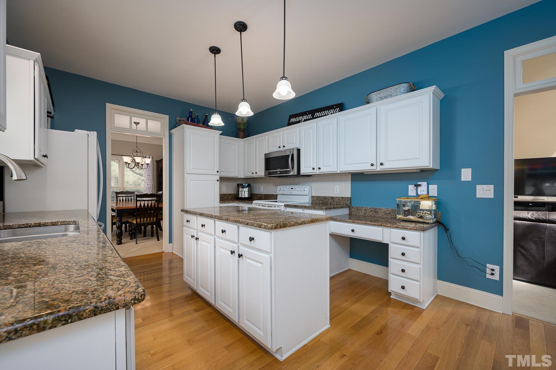 701 Modena Drive Cary, NC 27513 - Photo 11 of 39 a kitchen with stainless steel appliances granite countertop a sink stove and refrigerator