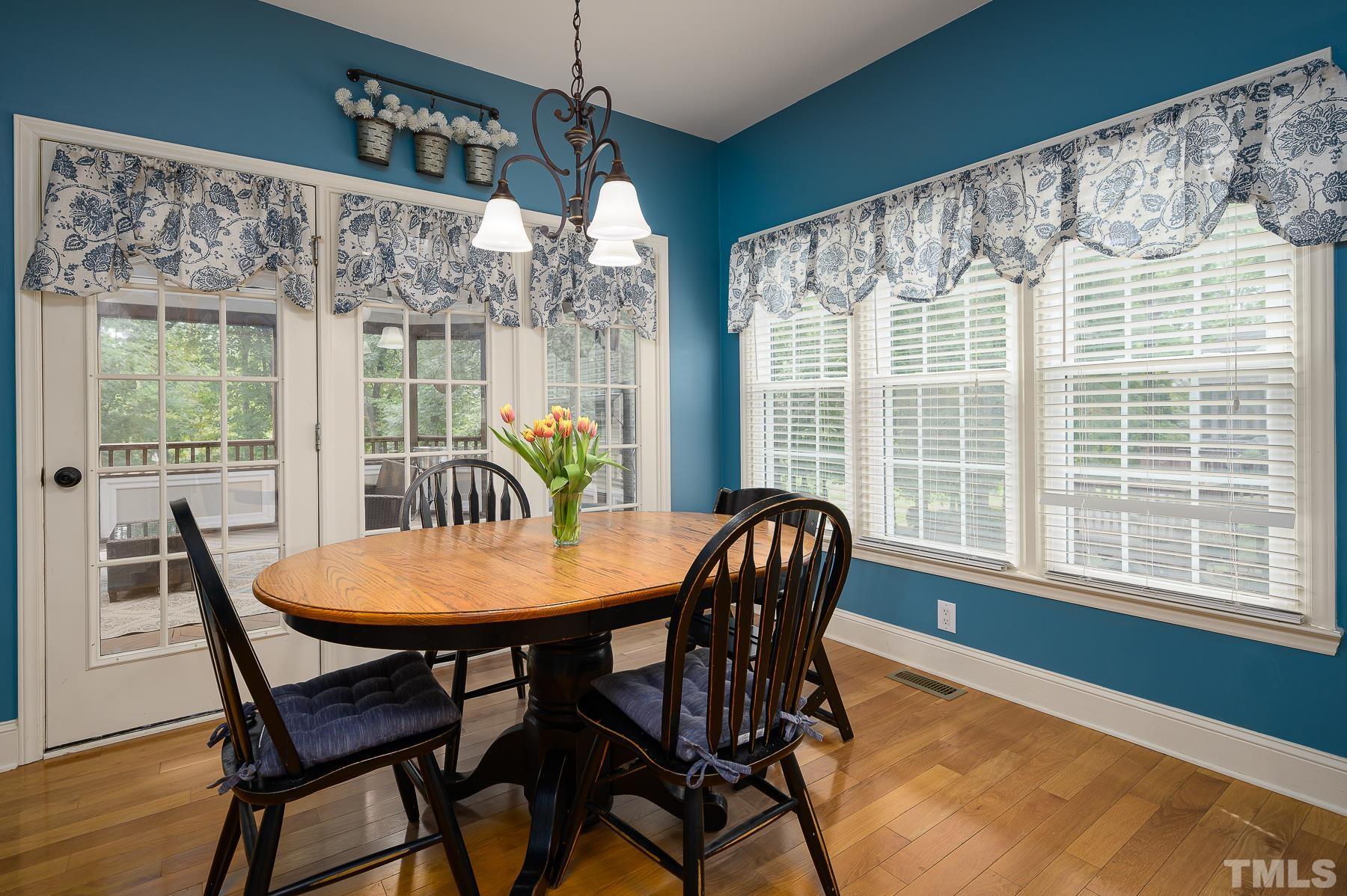 701 Modena Drive Cary, NC 27513 - Photo 13 of 39 a dining room with furniture a chandelier and wooden floor