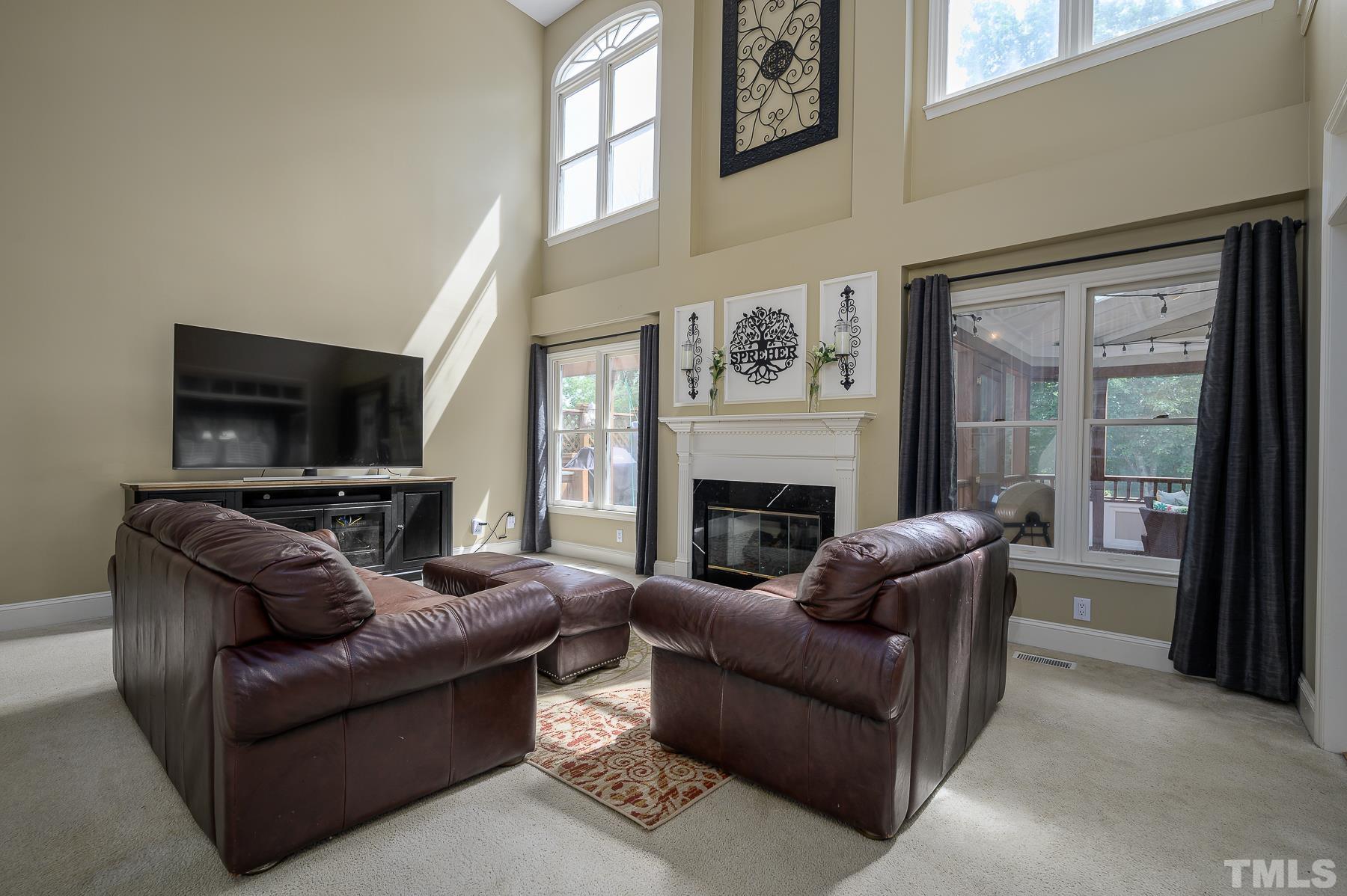 701 Modena Drive Cary, NC 27513 - Photo 16 of 39 a living room with furniture a flat screen tv and a fireplace