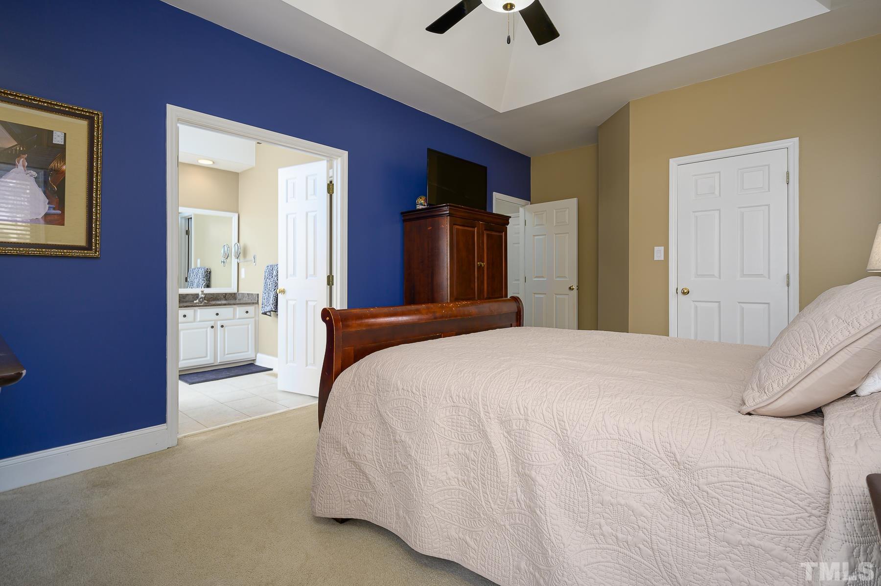 701 Modena Drive Cary, NC 27513 - Photo 22 of 39 a bedroom with a bed and a chandelier