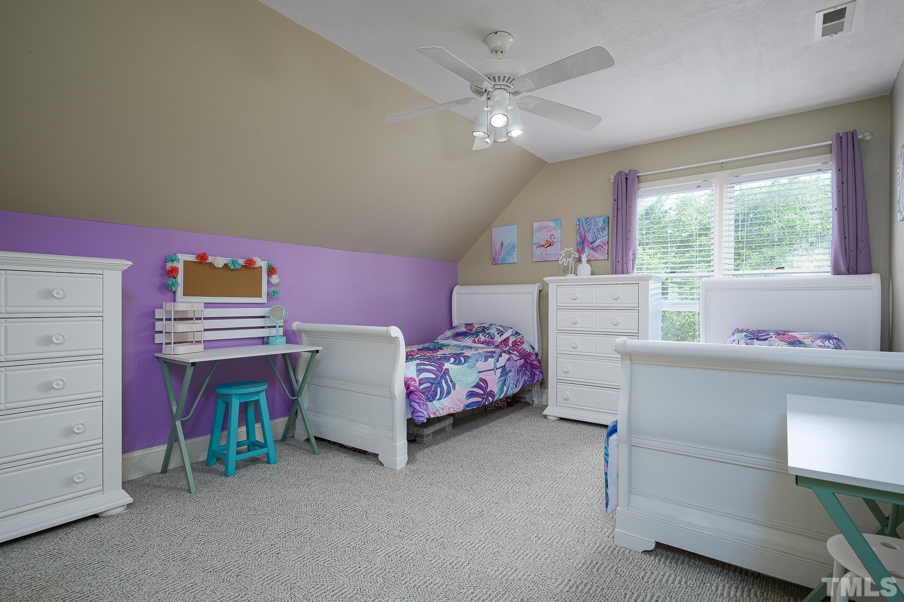 701 Modena Drive Cary, NC 27513 - Photo 29 of 39 a bedroom with a bed and a chandelier