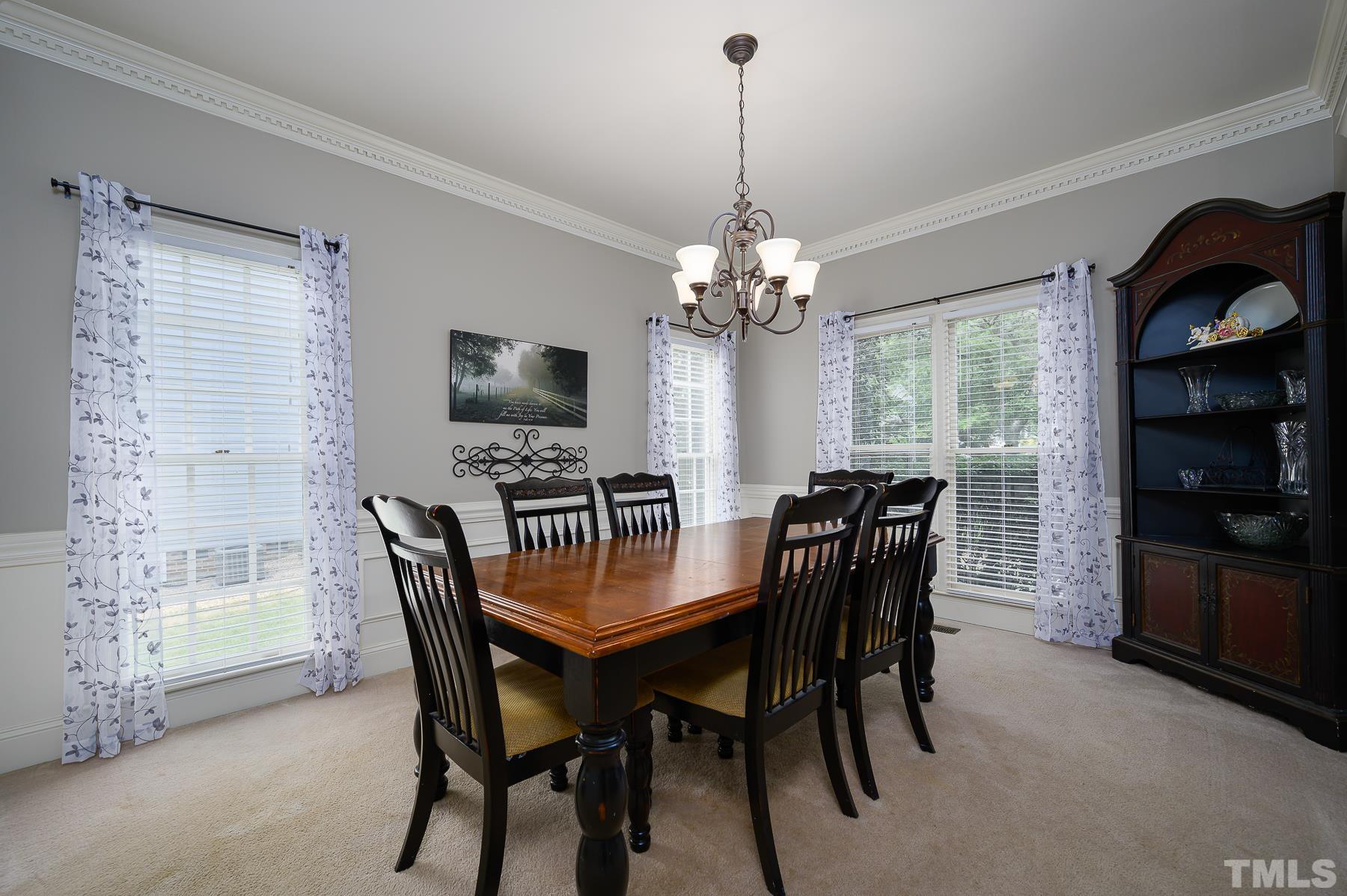 701 Modena Drive Cary, NC 27513 - Photo 8 of 39 a dining room with furniture a chandelier and window