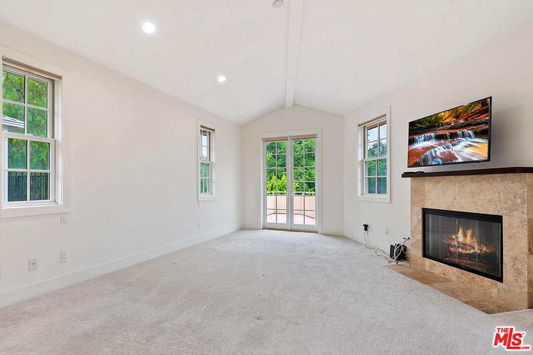 23550 Valley View Road Calabasas, CA 91302 - Photo 12 of 26 a view of an empty room with a fireplace and a window