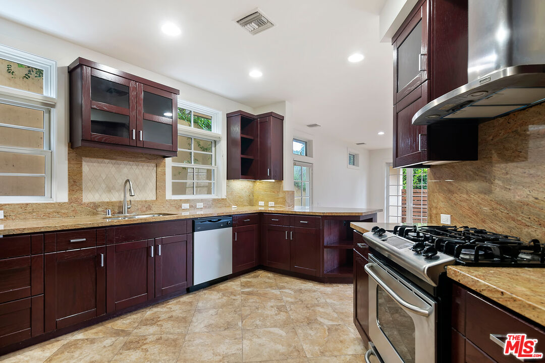 23550 Valley View Road Calabasas, CA 91302 - Photo 6 of 26 a kitchen with stainless steel appliances granite countertop wooden cabinets a stove top oven a sink and dishwasher