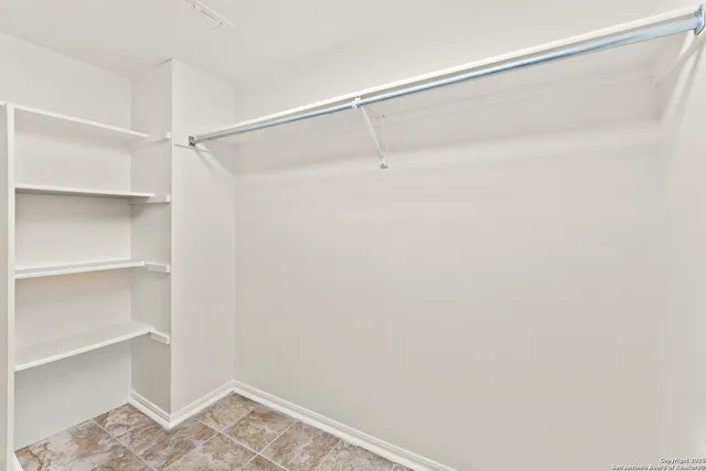 a view of walk in closet with empty racks