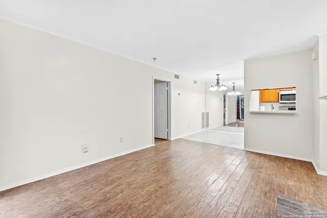 a view of empty room with wooden floor