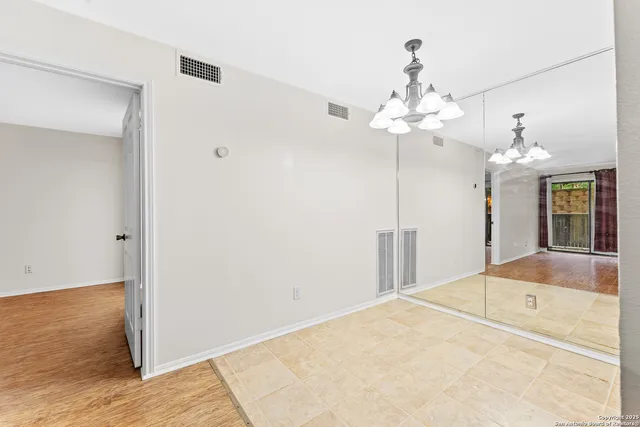 a view of a bedroom with a chandelier fan and kitchen view