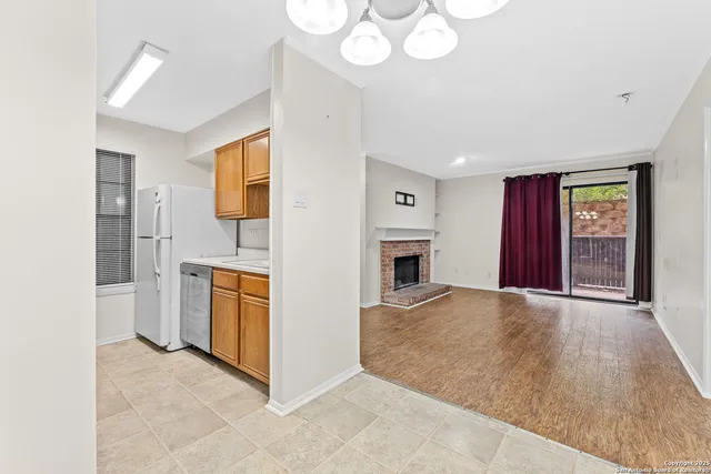 a view of an empty room with window and fireplace