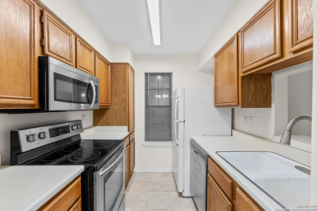 a kitchen that has a sink and a stove top oven