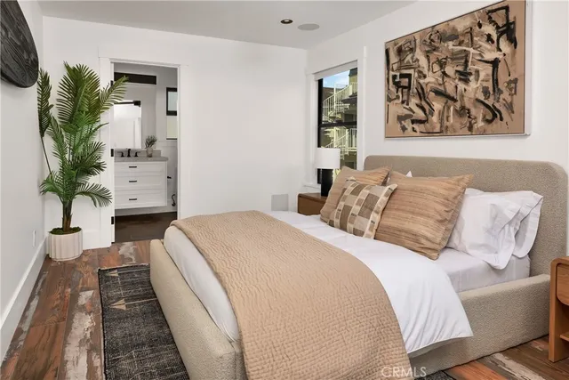 a bedroom with a large bed and a potted plant