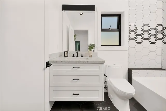 a bathroom with a sink a toilet a mirror and shower curtain