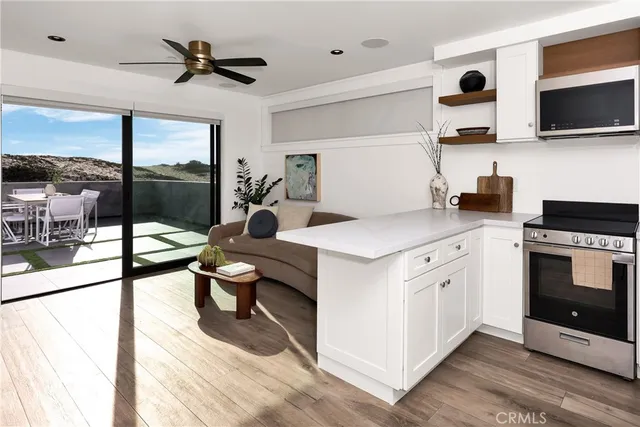 a living room with stainless steel appliances kitchen island granite countertop a stove a sink and a microwave