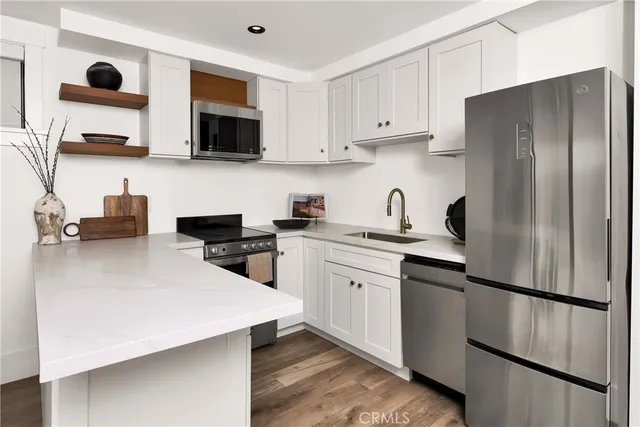a kitchen with stainless steel appliances a refrigerator sink and microwave