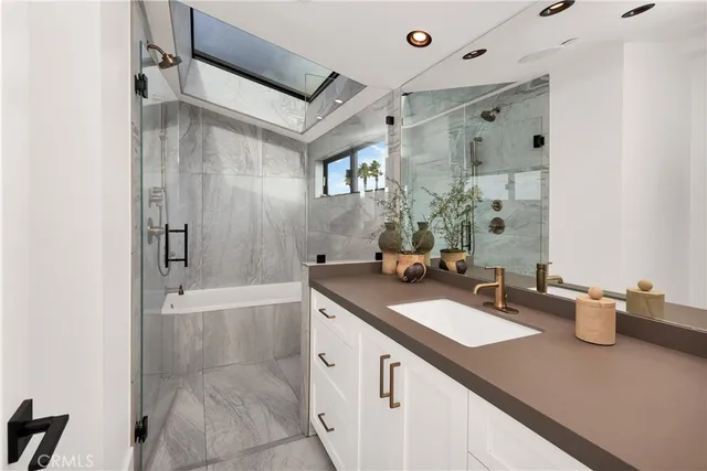 a bathroom with a sink double vanity granite tub shower and a mirror