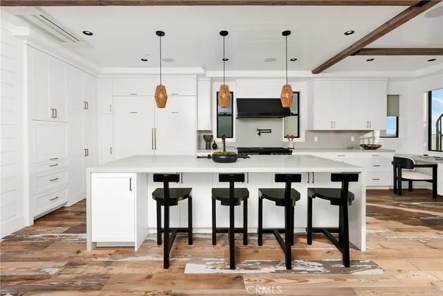 a kitchen with stainless steel appliances kitchen island granite countertop a table chairs sink and cabinets