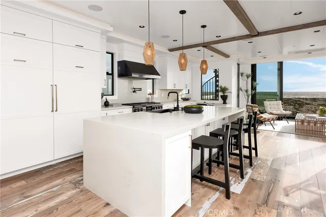 a kitchen with stainless steel appliances kitchen island granite countertop a table chairs sink and cabinets