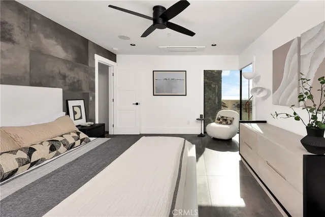 a bedroom with a bed and a flat tv screen on the dresser