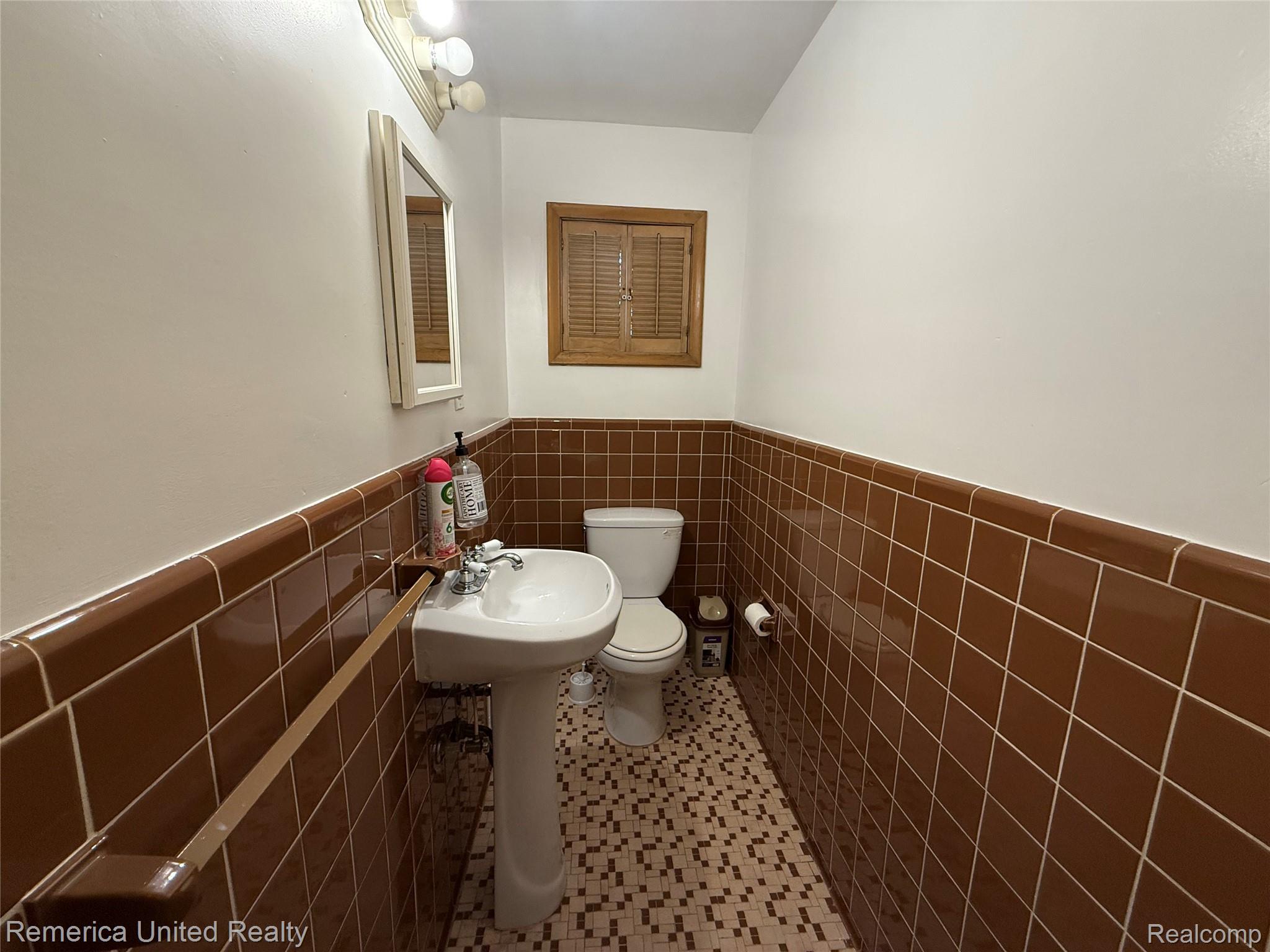 28231 Farmington Road Farmington, MI 48334 - Photo 12 of 18 Half bath with tile walls, a wainscoted wall, and tile patterned flooring