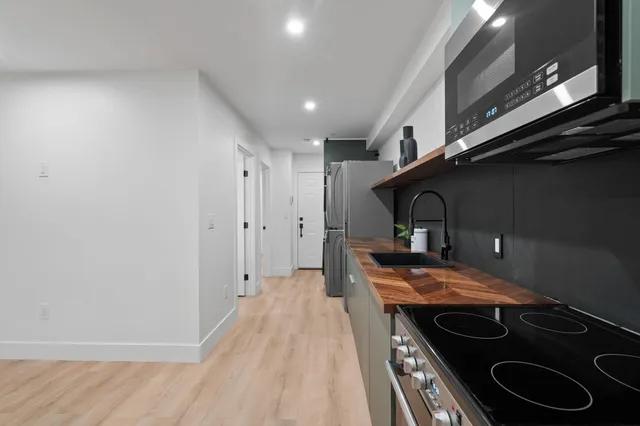 a view of a kitchen with a sink and a refrigerator