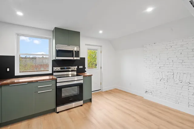 a kitchen with stainless steel appliances granite countertop a stove a sink and a refrigerator