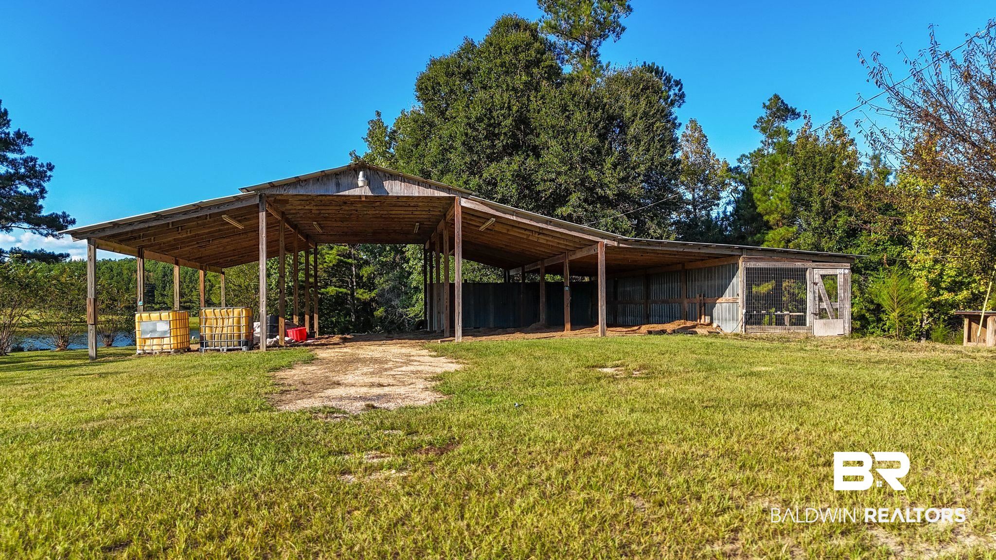 888 Mobile Cut-Off Road St. Stephens, AL 36569 - Photo 47 of 54 Exterior space featuring a yard, an outbuilding, and a pole building