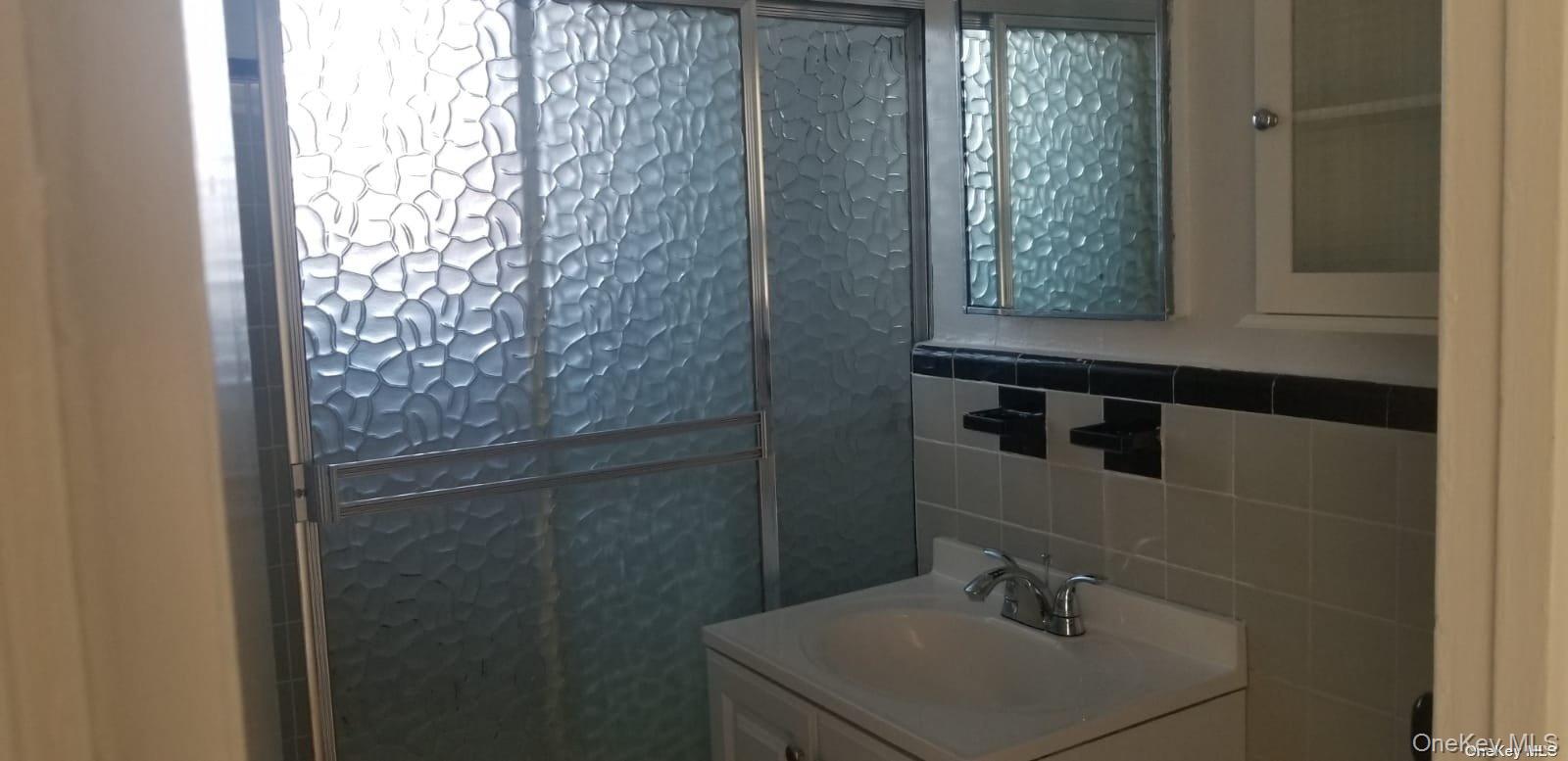 73-45 210th Street, Unit 4B Queens, NY 11364 - Photo 6 of 12 a bathroom with a sink and a mirror