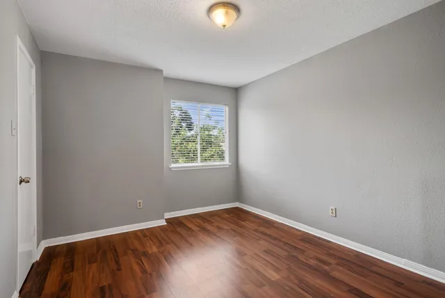 a view of an empty room with wooden floor