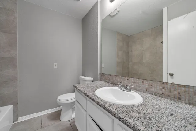 an aerial view of a residential houses with outdoor space and a lake view