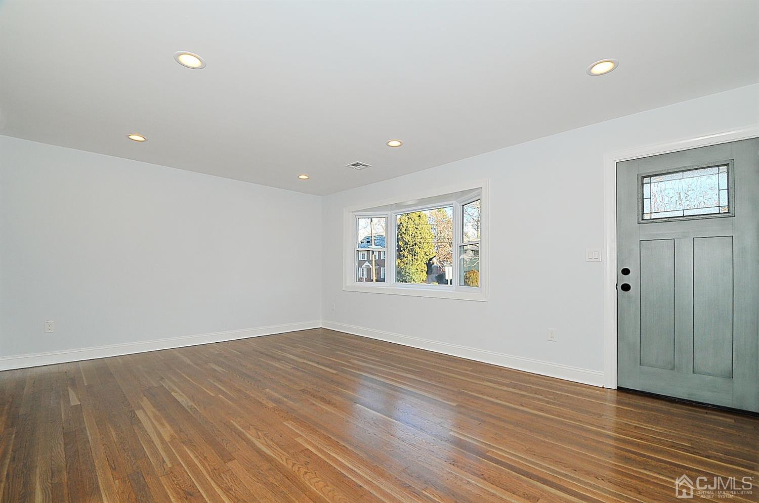24 Prescott Street Edison, NJ 08817 - Photo 2 of 27 a view of an empty room with wooden floor and window