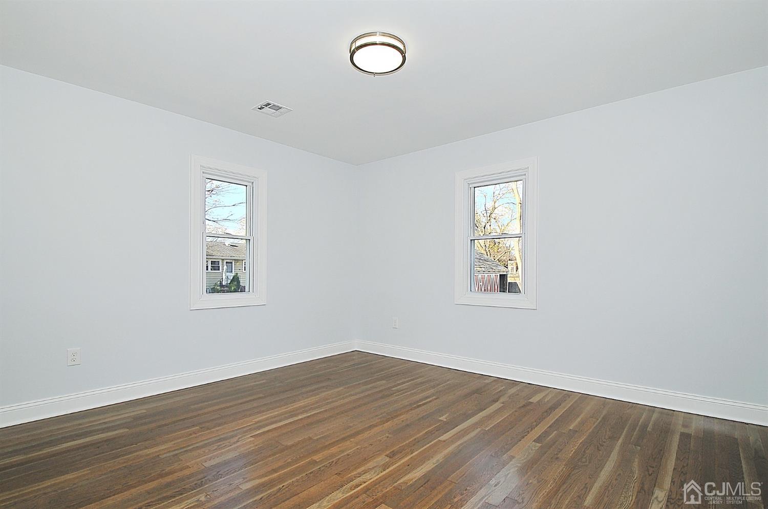 24 Prescott Street Edison, NJ 08817 - Photo 11 of 27 an empty room with wooden floor and windows