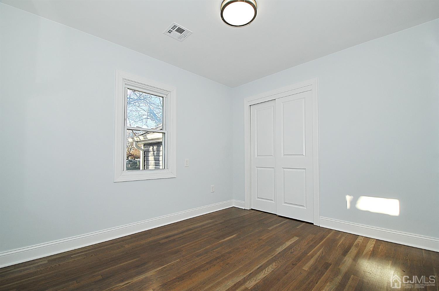 24 Prescott Street Edison, NJ 08817 - Photo 14 of 27 an empty room with wooden floor and windows