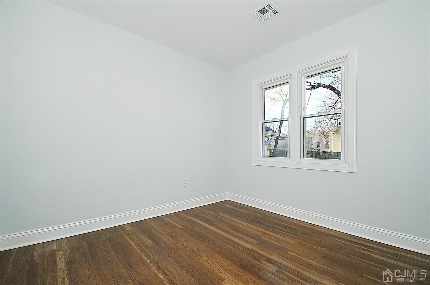 24 Prescott Street Edison, NJ 08817 - Photo 17 of 27 a view of an empty room with wooden floor and a window