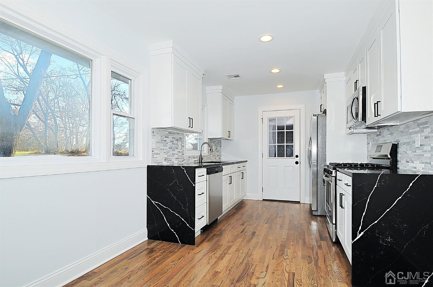 24 Prescott Street Edison, NJ 08817 - Photo 5 of 27 a kitchen with granite countertop a stove top oven and sink
