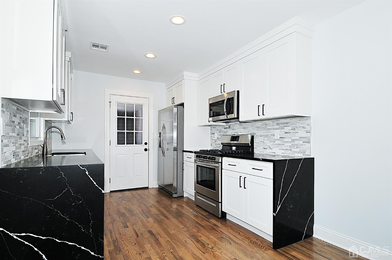 24 Prescott Street Edison, NJ 08817 - Photo 6 of 27 a kitchen with a sink appliances and cabinets