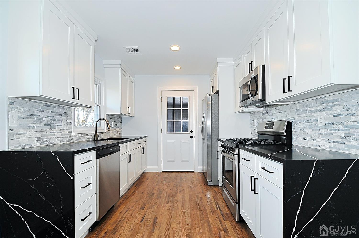 24 Prescott Street Edison, NJ 08817 - Photo 7 of 27 a kitchen with granite countertop a sink stove and cabinets